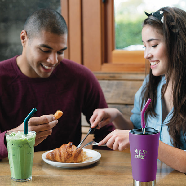 Couple using Klean Kanteen Straws and Klean Kanteen Tumbler while eating a Croissant